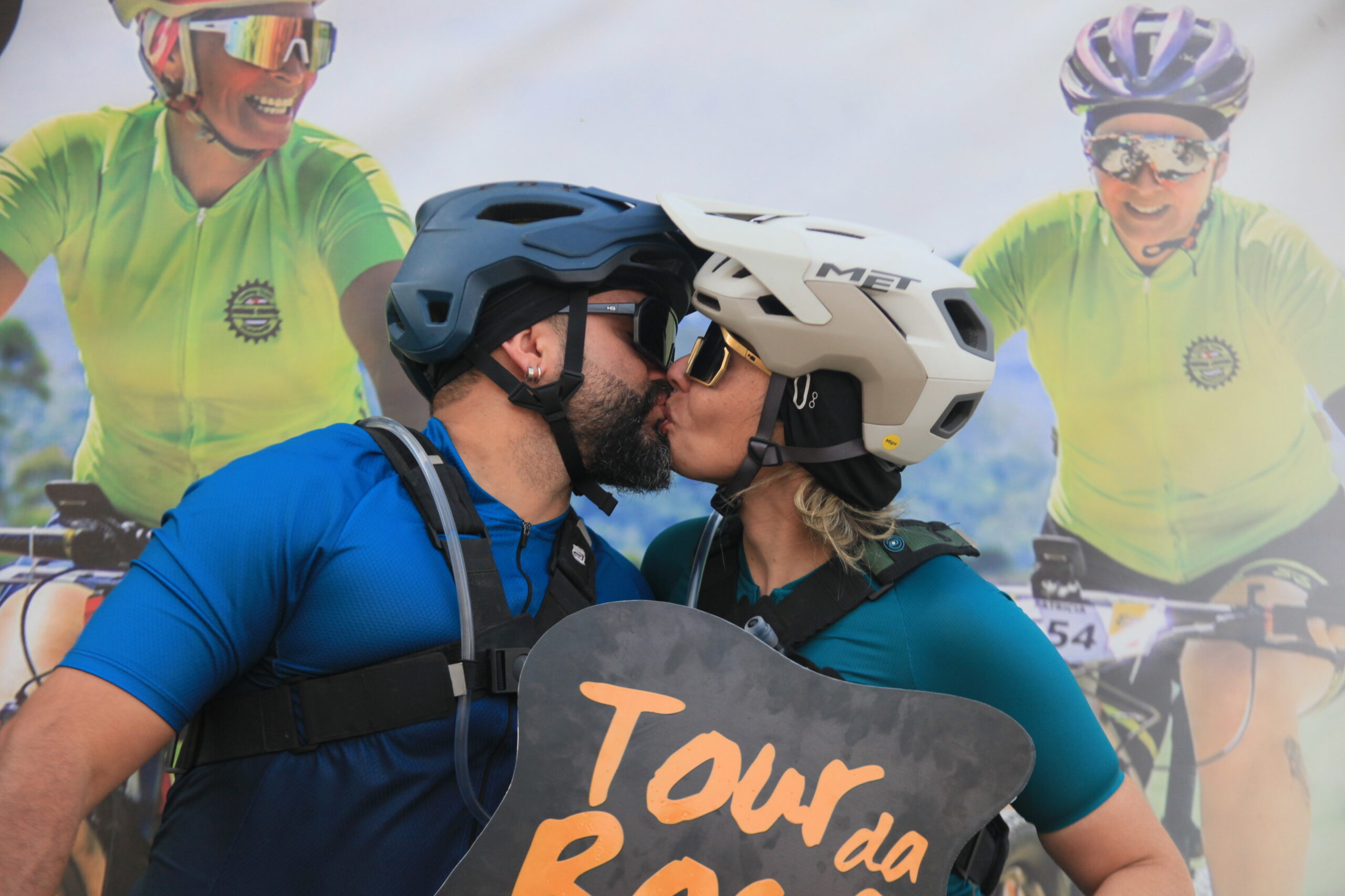 Casal de ciclistas, comemorando o Tour da Roça com um beijo