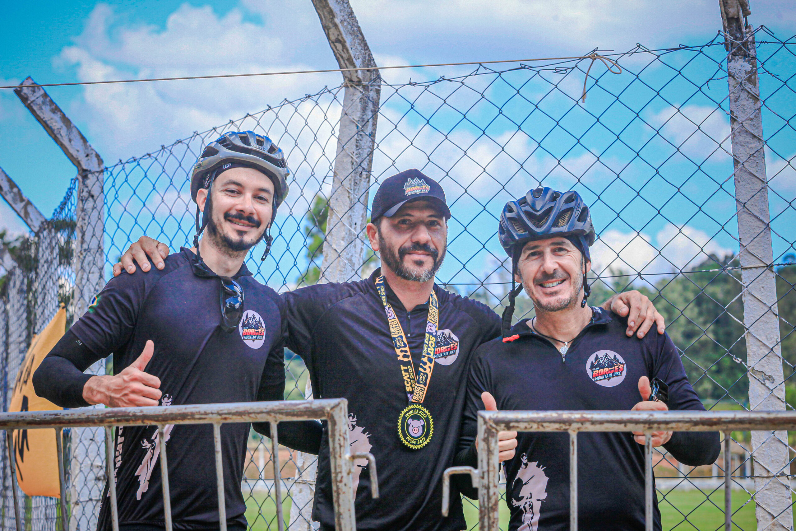 Ciclista comemorando a chegada e recebendo medalha no Tour da Roça em Amparo